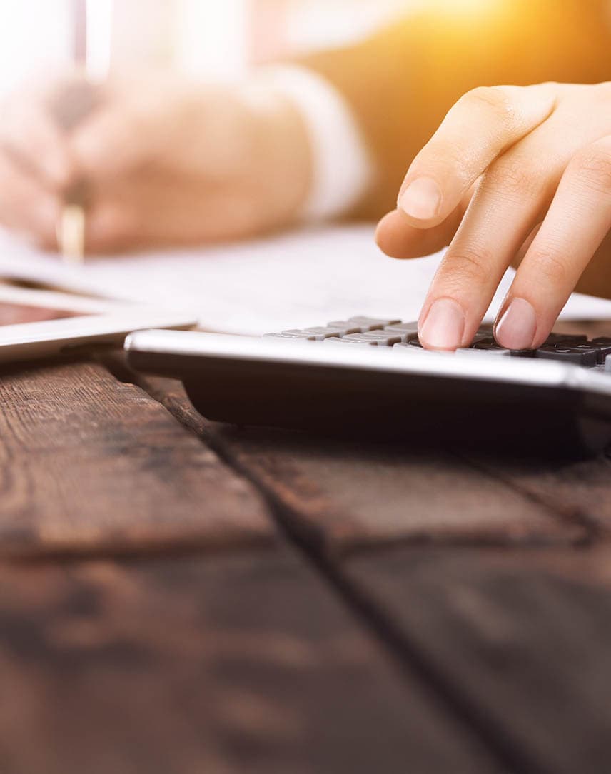 Hand tippt etwas auf Taschenrechner