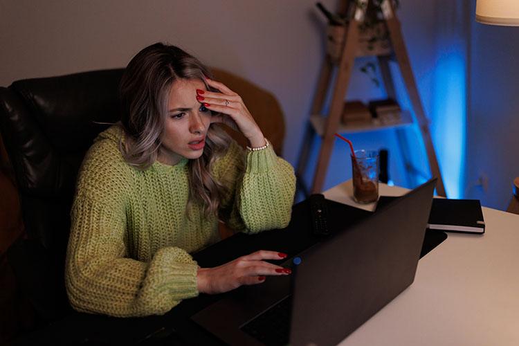 Frau sitzt verzweifelt am Laptop