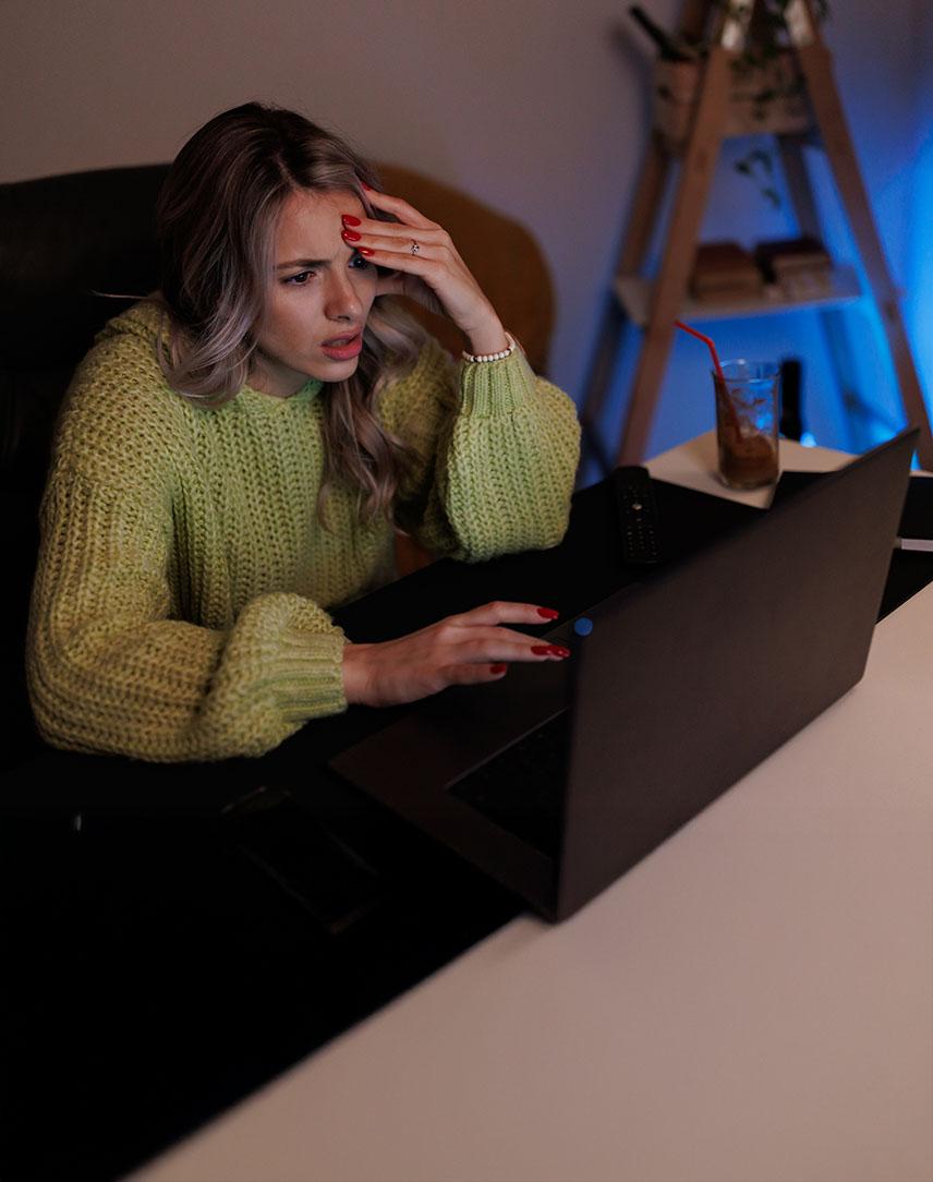 Frau sitzt verzweifelt am Laptop