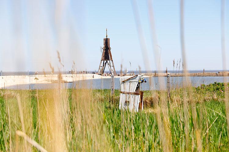 Kugelbake- von Cuxhaven und Strandkorb durch Seegras fotografiert.