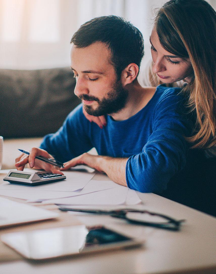 Mann und Frau rechnen etwas auf einem Taschenrechner
