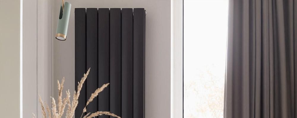 Schwarzer Niedertemperatur-Heizkörper vor weißer Wand