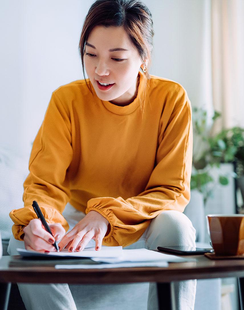 Frau notiert sich etwas auf einem Zettel