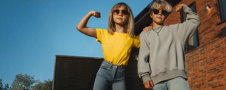 Vater und Tochter, die auf einer Wärmepumpe sitzt, unterhalten sich in ihrem Garten