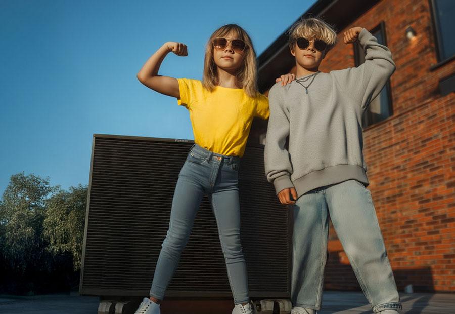 Vater und Tochter, die auf einer Wärmepumpe sitzt, unterhalten sich in ihrem Garten