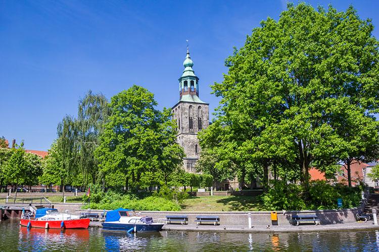 Boote auf der Vechte vor dem historischen Kirchturm von Nordhorn.