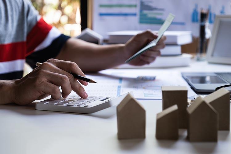 Hände mit Zettel und Taschenrechner