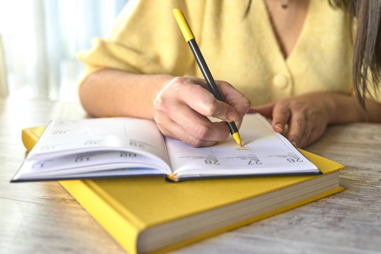 Frau notiert ihren Umzugstermin in einem Kalender